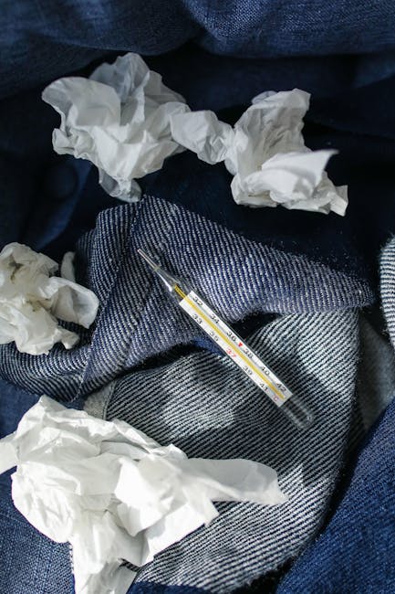 Et termometer og brukte papirlommetørklær symboliserer forkjølelsessymptomer